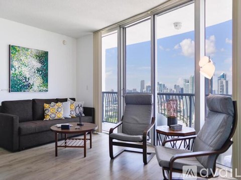 A living room with a couch, two chairs, and a table with a book on it.
