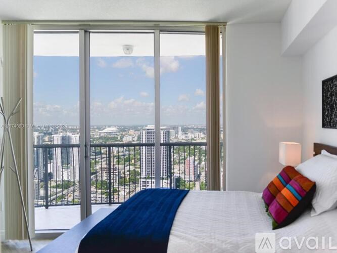 A bedroom with a large bed and a view of the city.