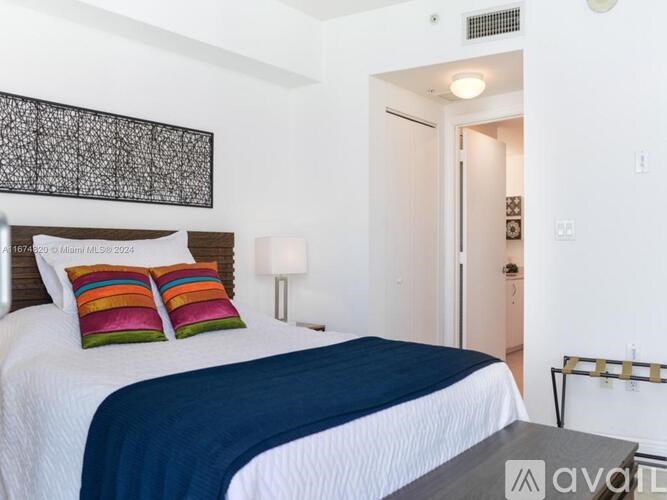 A bedroom with a bed, nightstand, and lamp.