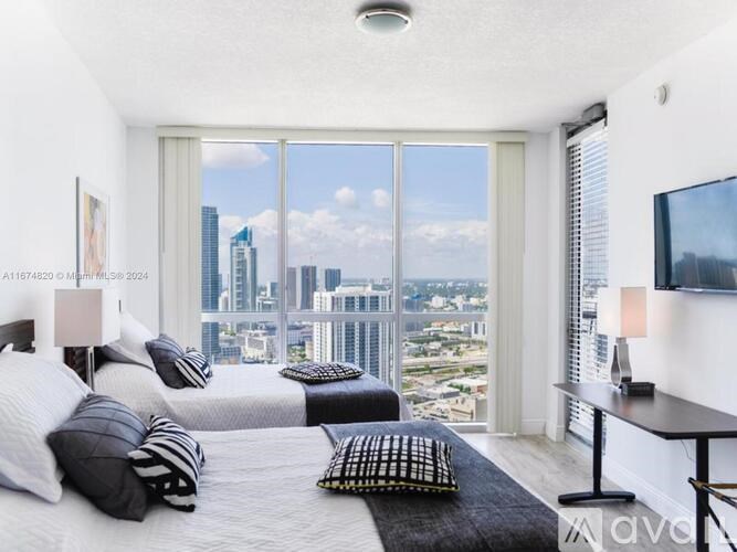 A bedroom with a large bed and a view of the city.