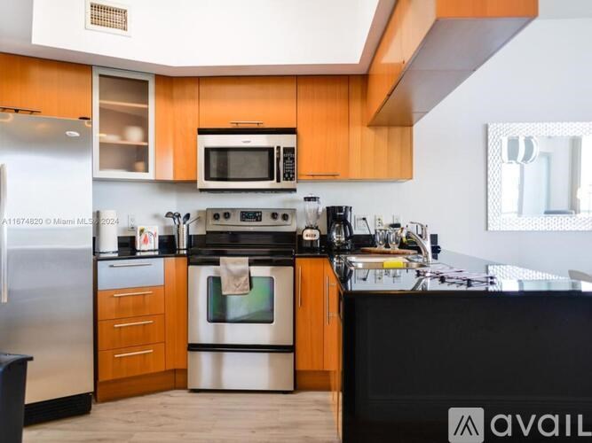 A kitchen with wooden cabinets and a black countertop.