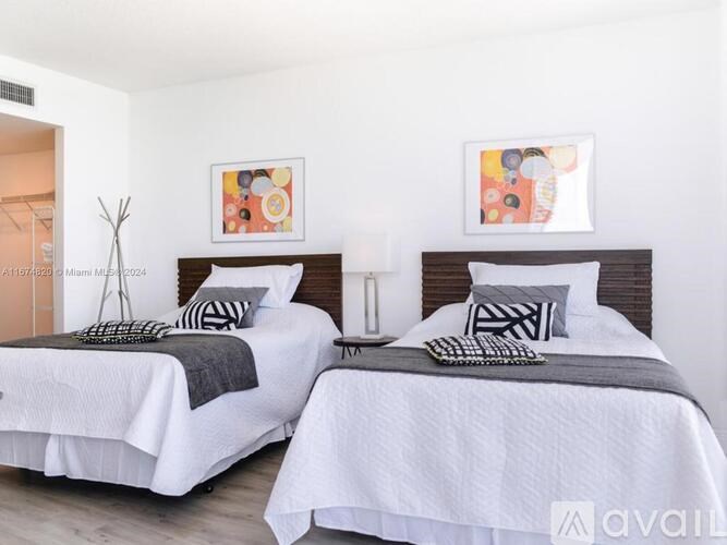 Two twin beds with white bedding and pillows in a room.