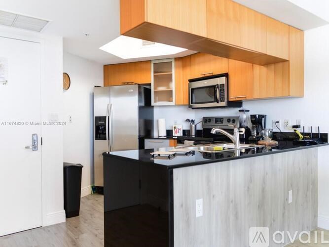 A kitchen with black countertops and wooden cabinets.