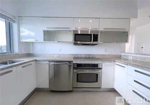 A modern kitchen with white cabinets and stainless steel appliances.