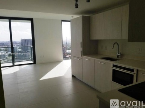 A kitchen with white cabinets and a black countertop.