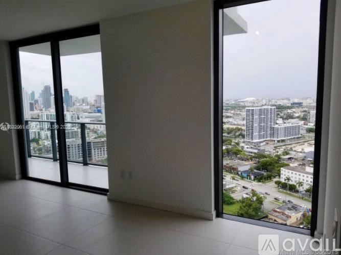 A room with a large window overlooking a cityscape.