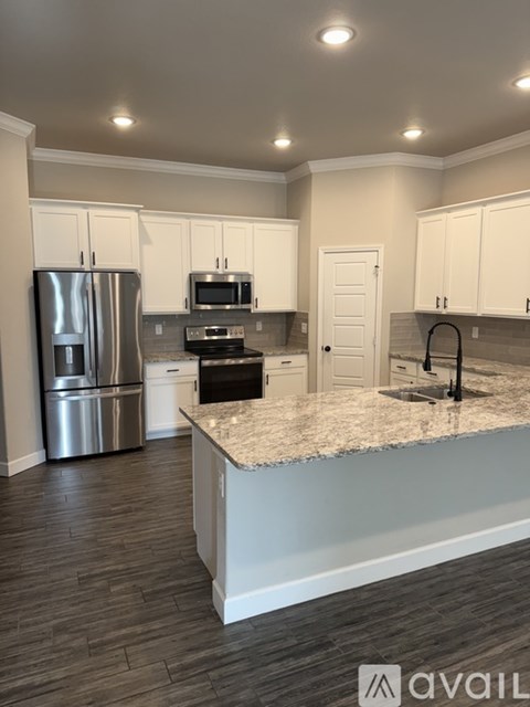 A kitchen with a granite countertop and stainless steel appliances.