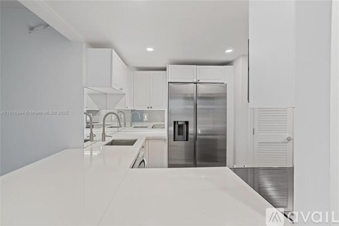 A modern kitchen with white cabinets and appliances.
