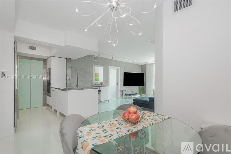 A modern kitchen with a glass table and chairs.