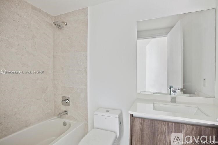 A bathroom with a tub, toilet, and sink.