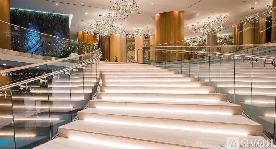 A staircase with a glass railing and wooden steps.