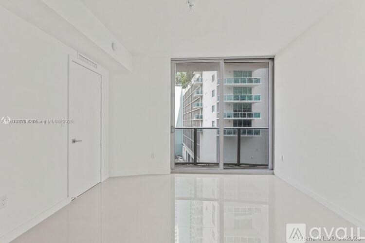 A spacious, empty room with a large window overlooking a cityscape.