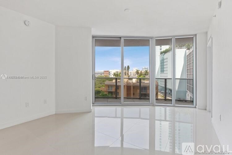 A large empty room with a view of the city outside the window.