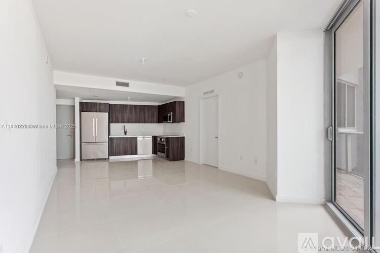 A spacious, empty kitchen with white walls and a large island.