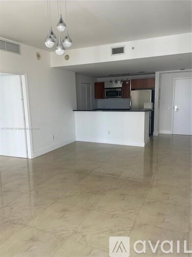 A spacious kitchen with a marble floor and a small dining area.