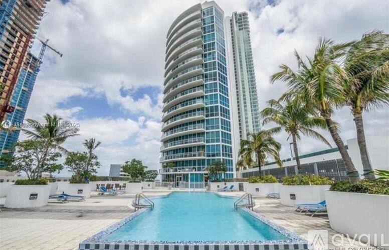 A pool area with a large swimming pool and a building in the background.