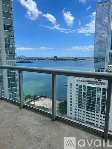 A balcony overlooks a body of water with buildings in the distance.