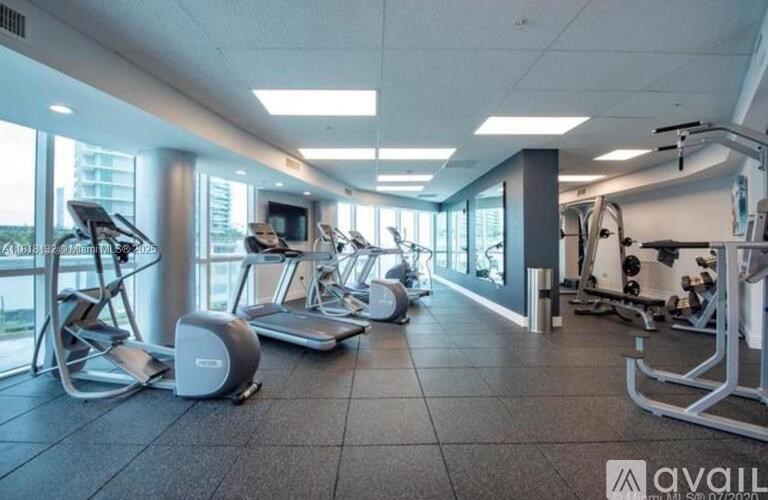 A gym with treadmills, elliptical machines, and other exercise equipment.
