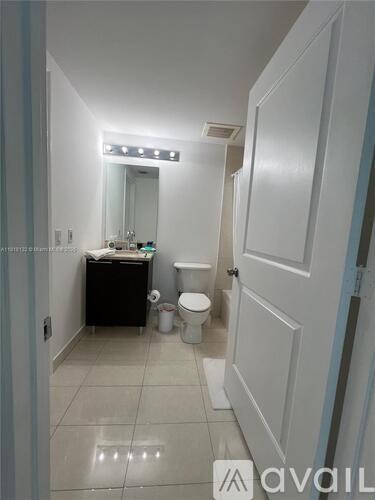 A bathroom with a toilet, sink, and mirror.