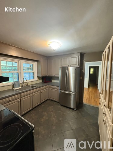 A kitchen with a stove top oven, sink, and refrigerator.