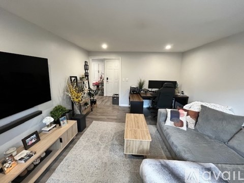A living room with a grey couch and a wooden coffee table.