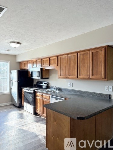 A kitchen with wooden cabinets and a black countertop.