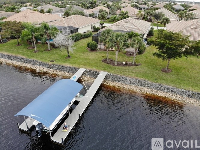 A boat is docked at a pier in a residential area.
