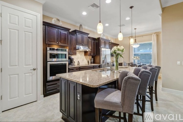 A kitchen with dark brown cabinets and a granite countertop.