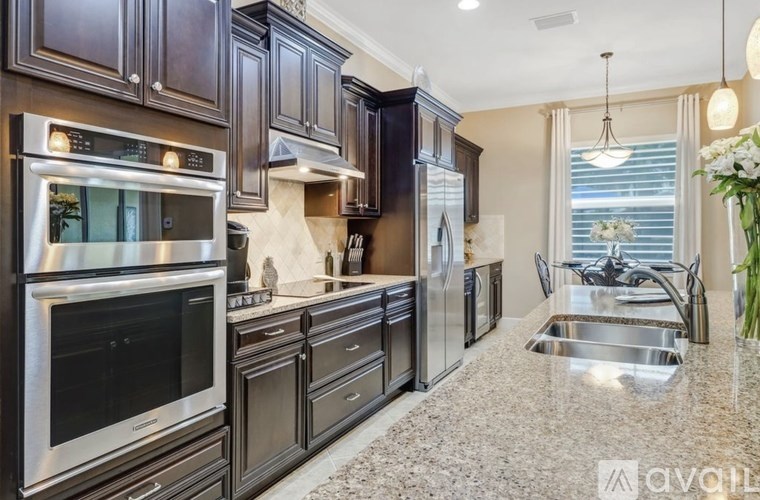 A kitchen with dark wood cabinets and stainless steel appliances.