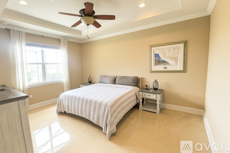 A bedroom with a bed, nightstand, and a ceiling fan.