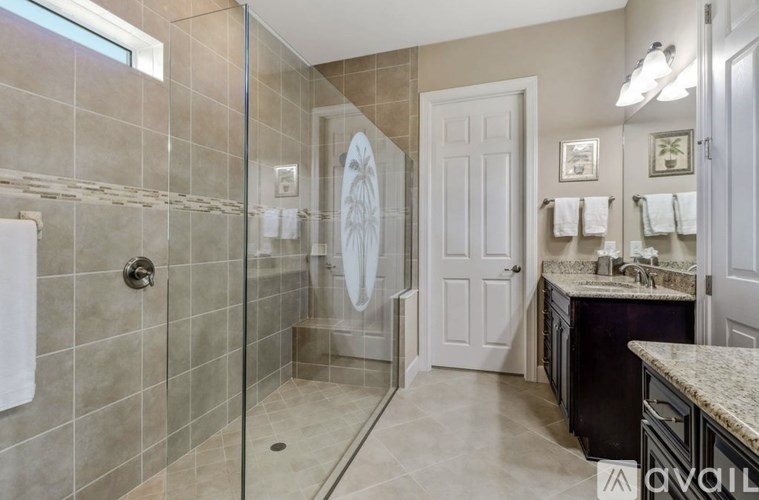 A bathroom with a walk-in shower and a sink vanity.