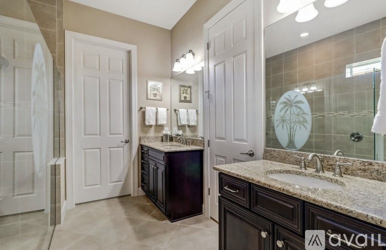 A bathroom with a sink, mirror, and two doors.