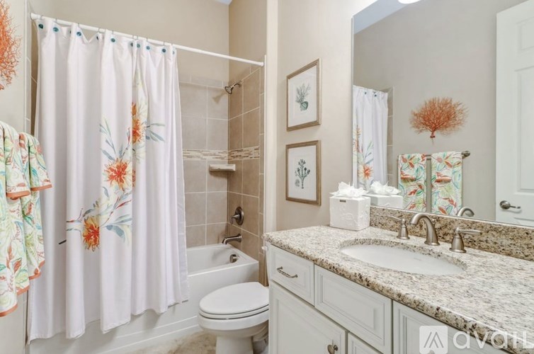 A bathroom with a floral shower curtain and matching towel.