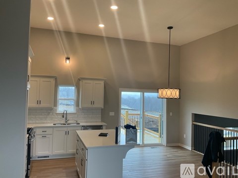 A modern kitchen with a large island and a balcony.