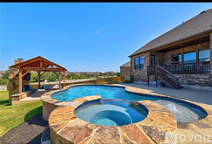 A large outdoor swimming pool with a wooden pavilion.