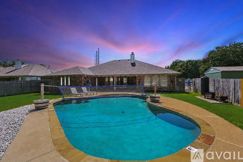 A pool with a basketball hoop and a house in the background.