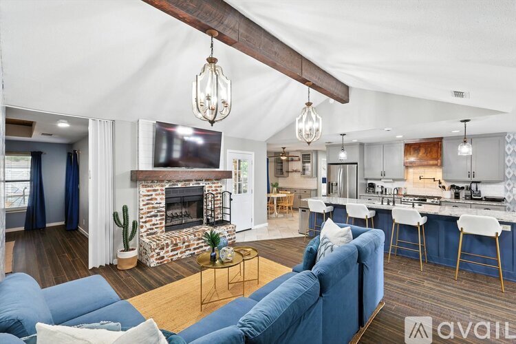 A living room with a blue couch and a fireplace.