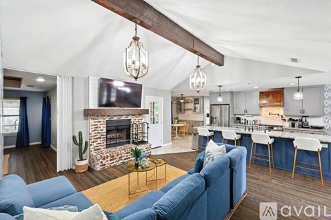 A living room with a blue couch and a fireplace.