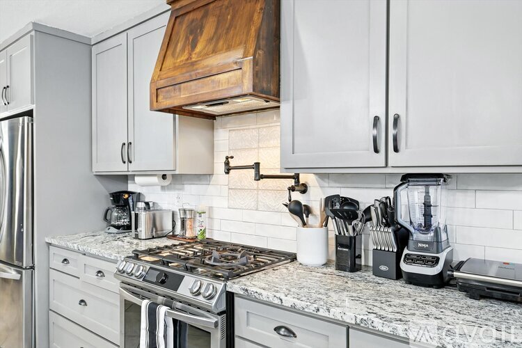 A kitchen with a stove top and a refrigerator.