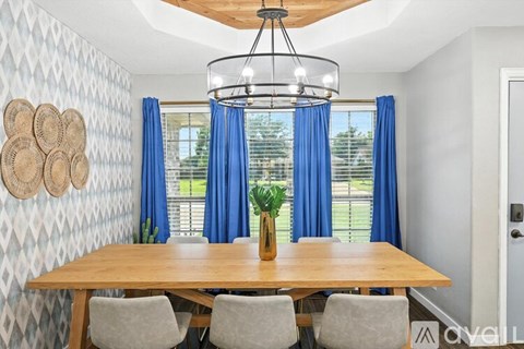 A dining room with a wooden table and chairs.