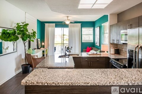 A kitchen with a granite countertop and a dining table with chairs.
