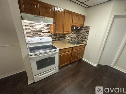 A kitchen with a white oven and wooden cabinets.