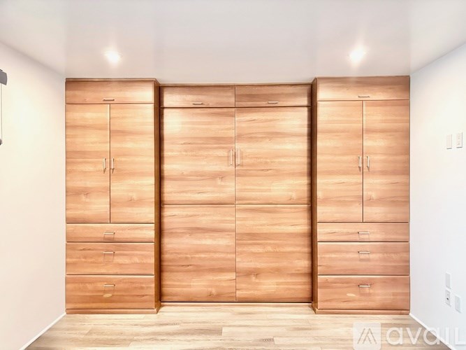 Closet with wooden doors and drawers.