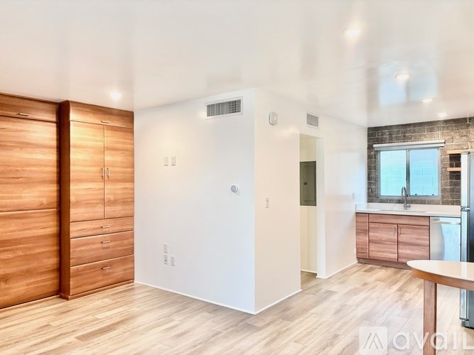 A kitchen with wooden floors and a brick wall.