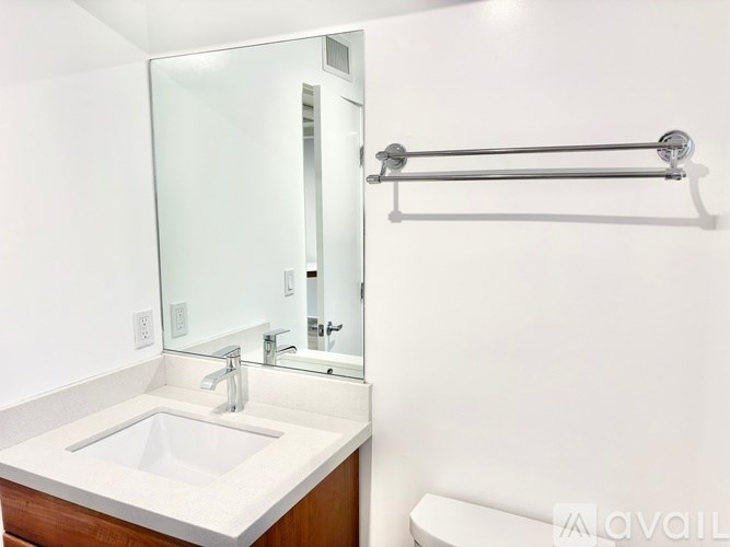 A white sink in a bathroom with a mirror above it.