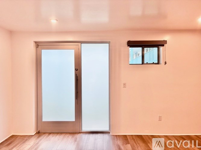 A room with a wooden floor and a glass door.