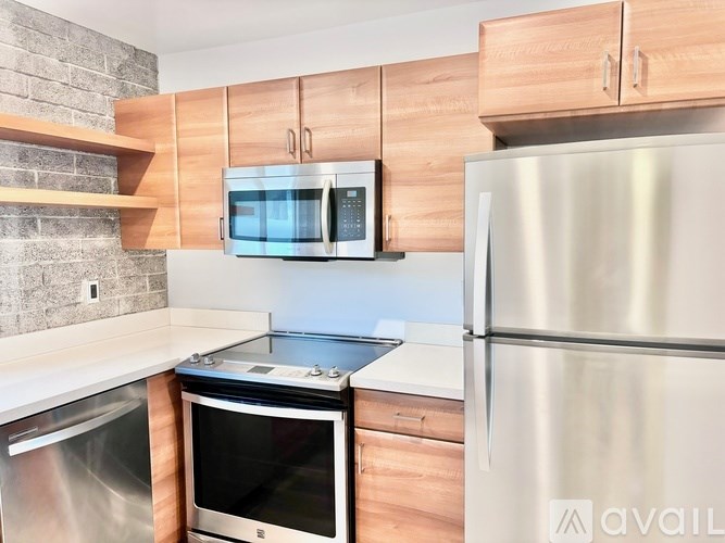 A kitchen with a stainless steel refrigerator, oven, and microwave.