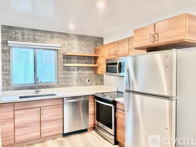 A kitchen with a refrigerator, sink, and oven.