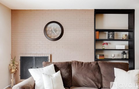 A living room with a brown couch and a fireplace.