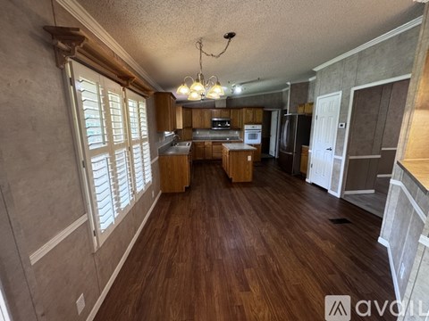A well-lit kitchen with wooden floors and a central island.